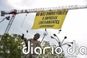 Activistas de Greenpeace despliegan una pancarta junto al Congreso en contra de subvenciones a empresas contaminantes