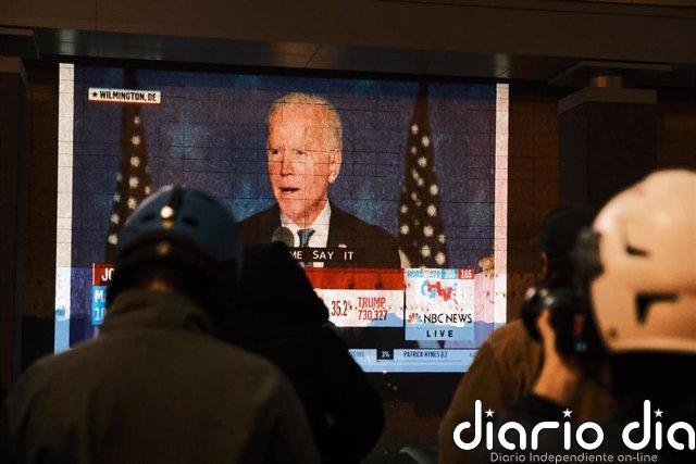 Biden promete que no parará "hasta que se cuenten todos los votos" Un grupo de personas observa el discurso de Joe Biden en Washington la noche electoral