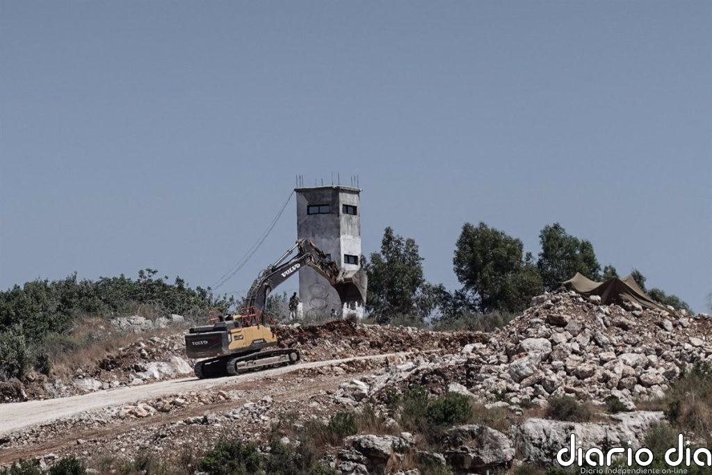 Una excavadora militar Israel derriba una torre de observación de los 'cascos azules' en el sur de Líbano