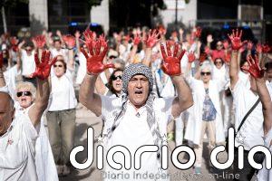 Sanitarios españoles homenajean a sus colegas en Gaza con batas blancas y manos pintadas de rojo