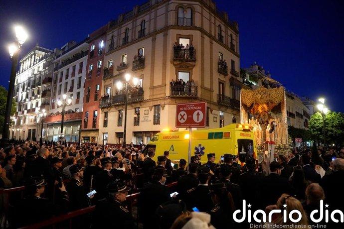 Una ambulancia atraviesa la avenida de la Constitución durante el tránsito de las cofradías en Sevilla