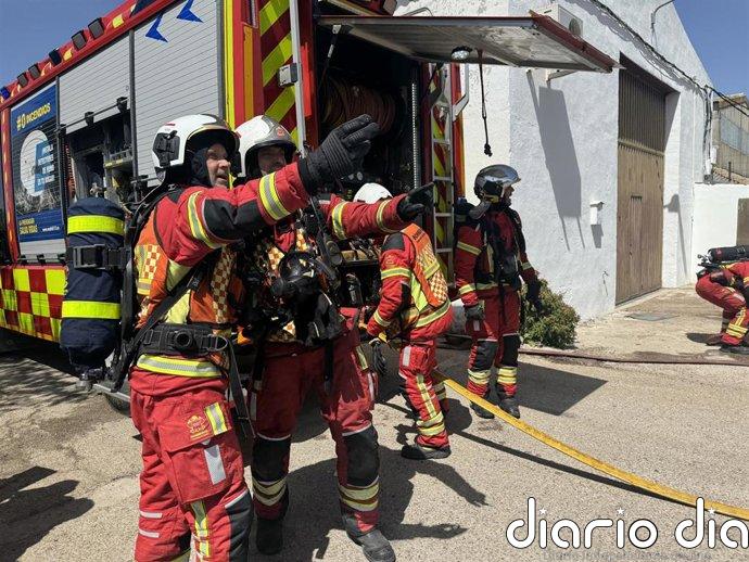 Bomberos extinguen un incendio en 13 vehículos pesados y material en desuso en un recinto al aire libre en Parla
