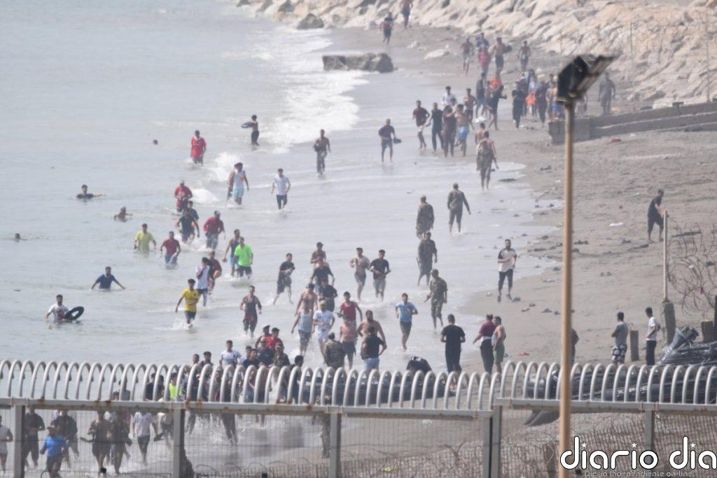 Cientos de personas cruzan a nado a Ceuta desde Marruecos con una multitud esperando al otro lado de la frontera