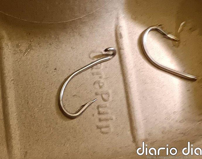 Un hombre se clava un anzuelo doble mientras manipula equipos de pesca en Laredo
