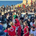 Cruz Roja y ONG reparten alimentos básicos a unos 2.000 migrantes en la Playa del Trampolín (Ceuta)