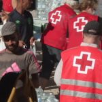 Furgones de la Policía Nacional escoltan a la Cruz Roja para el reparto de comida en Playa de Benítez