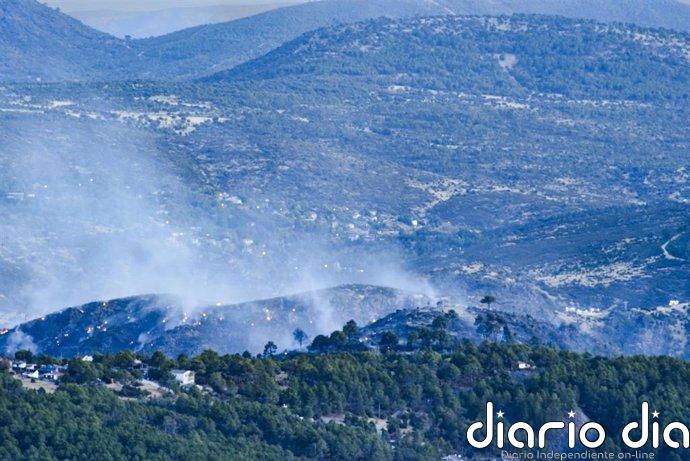 Bomberos rescatan a tres operarios que trabajaban en un puente en el río Cofio cerca del incendio de la M-505