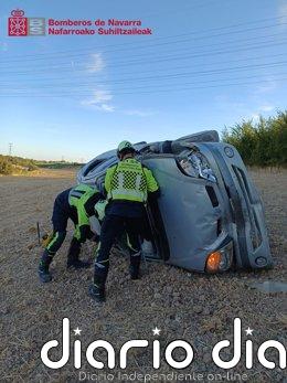 Herido un hombre de 74 años al salirse de la vía y volcar en Olite Efectivos de bomberos junto al coche siniestrado.