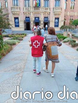 Más de 300 mayores de Córdoba participan en una jornada de promoción de la salud de Cruz Roja en el Rectorado Una voluntaria de Cruz Roja acompañada a una asistentes a las jornadas de promoción a la salud.