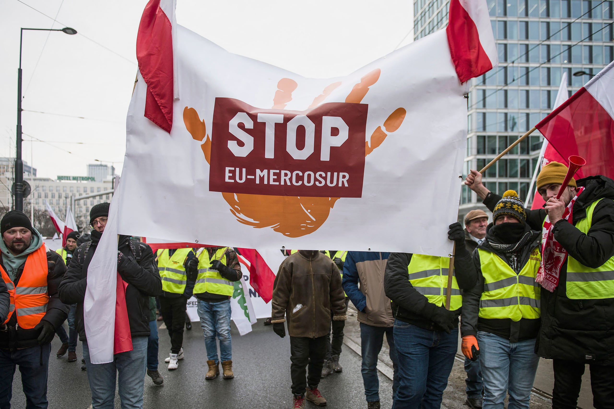 Manifestantes sostienen una gran pancarta que dice "STOP UE-Mercosur" en una calle